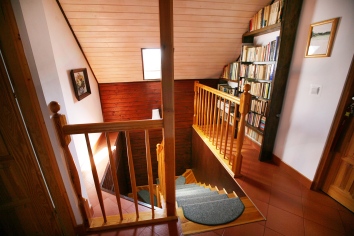 Piętro, schody, biblioteczka dla gości.
