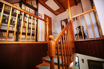 Piętro, schody, biblioteczka dla gości.